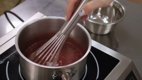 Closeup of a Pastry Chef Cooking Strawberry Jelly in the Kitchen of a Restaurant