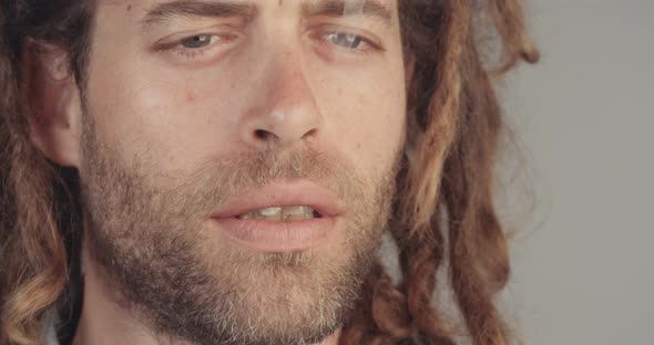 Man with dreadlocks smoking medicinal marijuana on white background