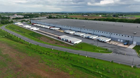 Massive warehouse for freight shipping in USA. American distribution center aerial reveal in America