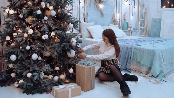 The Happy Girl Smiles Wide After She Has Finished Decorating the Christmas Tree