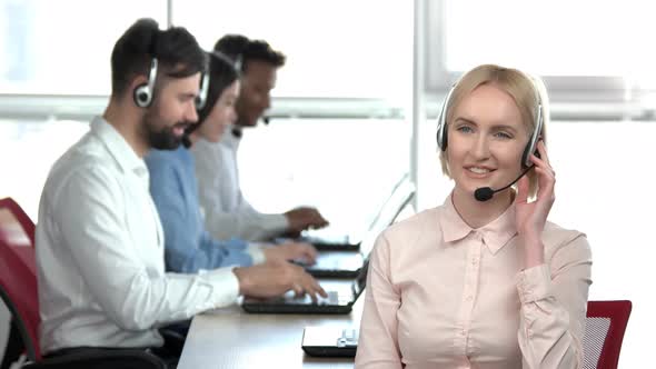 Smiling Lady Talking on Headset in the Office.