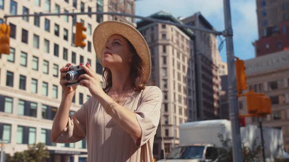 Smiling woman with a retro camera in Manhattan in New York