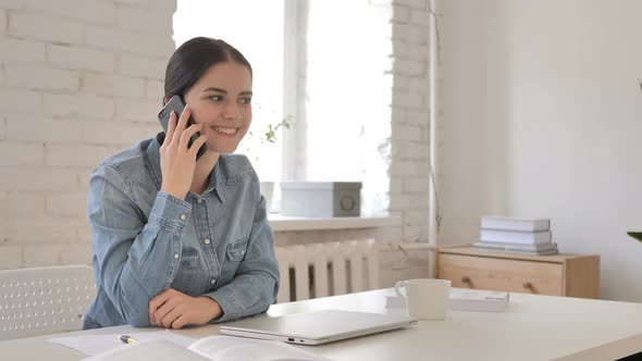 Woman Talking on Phone at Work