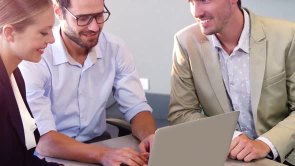 Businesspeople interacting over a laptop