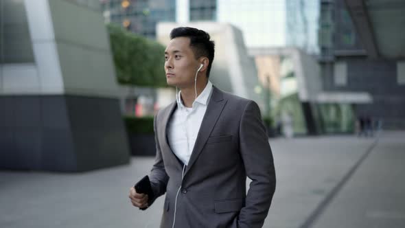 Real Time Shot of a Young Businessman Dancing with Headphones on the Street During a Break.