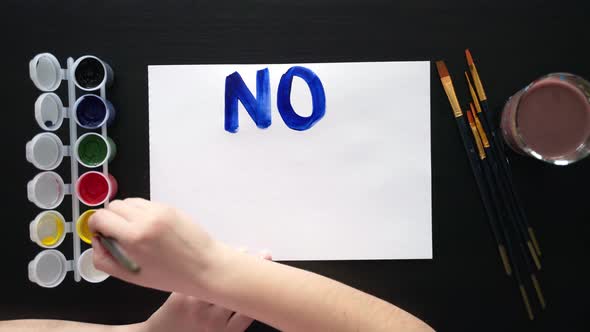 Man Paints Poster for Rally with the Slogan NO TO WAR