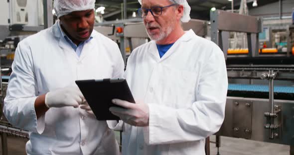 Workers discussing over digital tablet