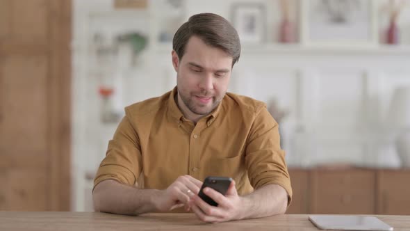 Upset Young Man Reacting to Loss on Smartphone