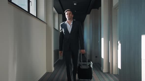 Business Man Walking at Hotel Corridor. Businessman Arriving at Business Hotel