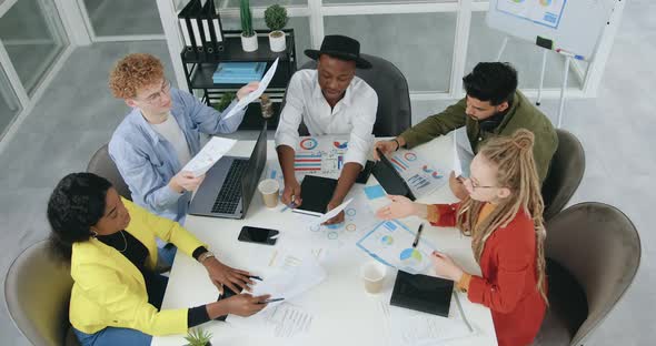 Team Exchanging with Documents while Working Together in Office Room