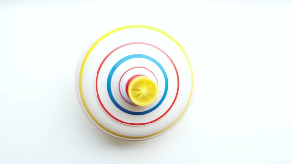 Untwisted whirligig, children toy spinning top spinning on white background.View from top.