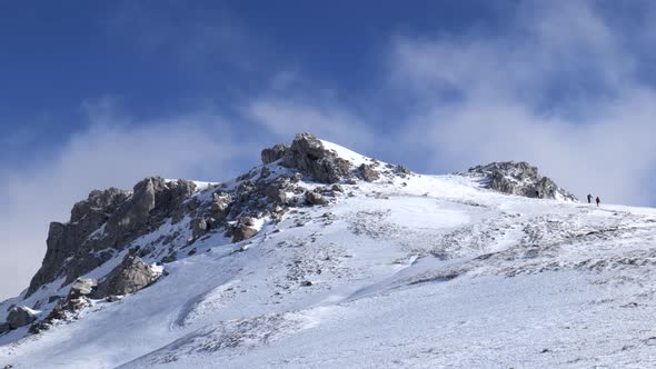 Mountaineers walking, hiking on a winter sunny day to reach the mountain peak