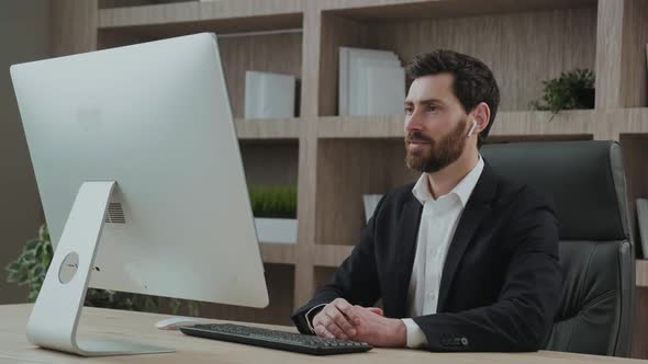 Representive Middle Aged Employee Leading an Online Meeting or Discusion in Front of the PC Screen