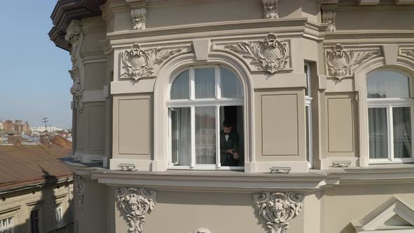 Aerial Shot of Stylish Groom Man Stay at Window at Home Gets Ready Before Date or Meeting with Bride