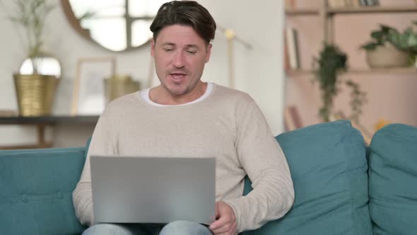 Online Video Call on Laptop By Middle Aged Man at Home