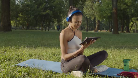 Female in Headphones with Tablet Pc Relaxing Outdoor