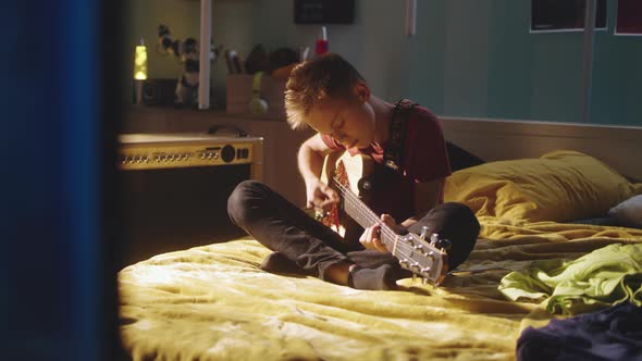 Teenager Playing Guitar Near Amplifier