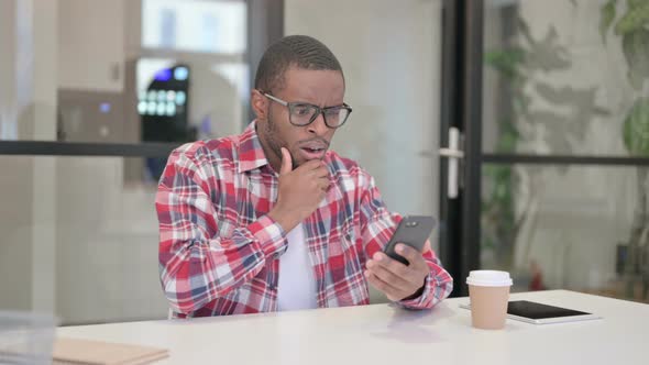 Upset African Man Reacting to Loss on Smartphone