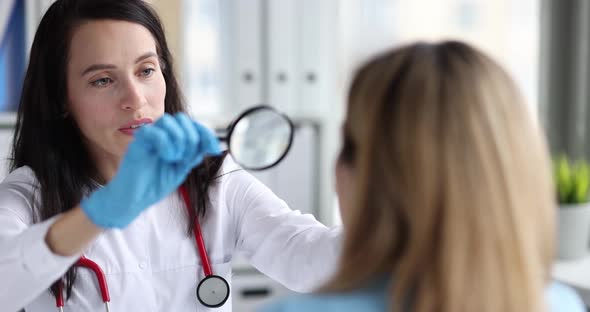 Woman Doctor Looking at Patient Face Through Magnifying Glass  Movie Slow Motion