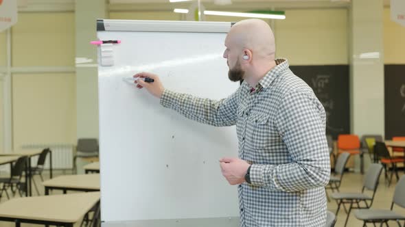 Teacher Records Mathematics Lessons He Stands and Writes with a Pen on a Flip Chart
