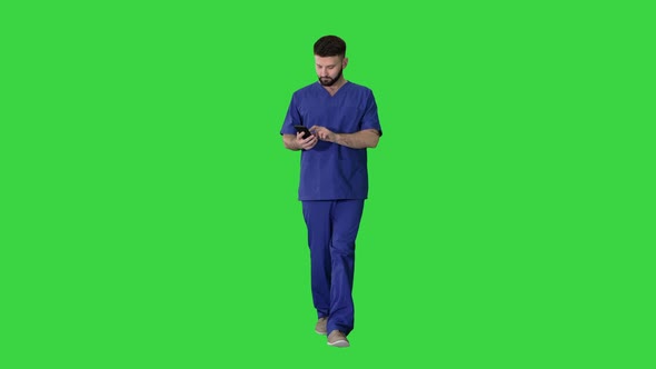 Surgeon Doctor Walking and Using His Phone on a Green Screen, Chroma Key