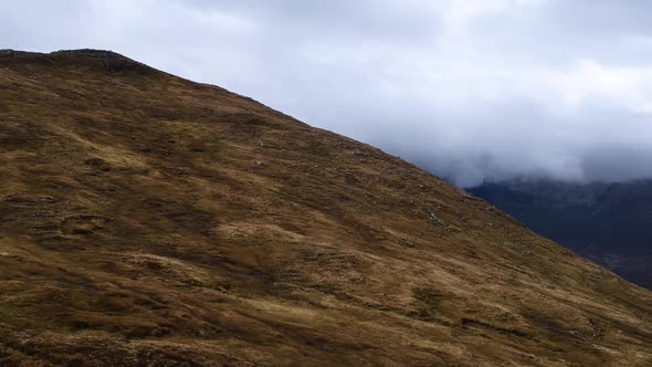 Cinematic panning drone shot of cloudy misty highland mountains