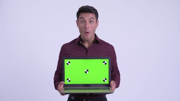 Young Happy Hispanic Businessman Showing Laptop and Looking Surprised