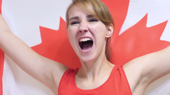 Canadian Young Woman Celebrating while Holding the Flag of Canada