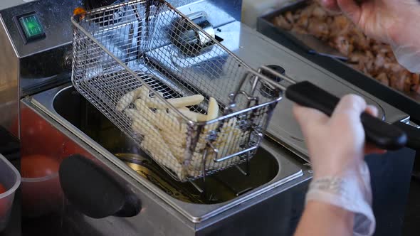 Cook Dipping Fries in Hot Oil