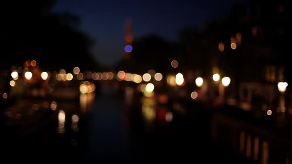 Illuminated canal at night in Amsterdam, Netherlands