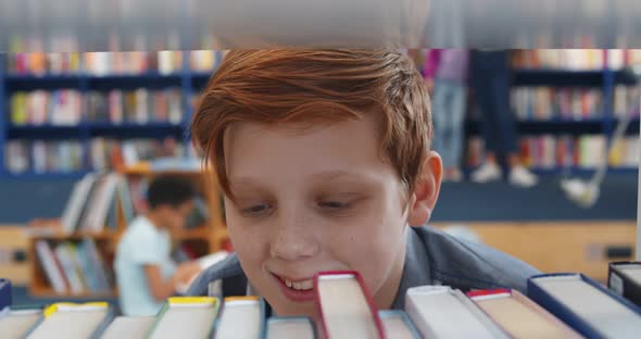 Close Up of Redhead Cute Schoolboy Taking Book From Bookshelf in Library