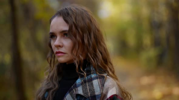 Portrait of Sad Young Woman in Forest in Autumn Day Walking Alone