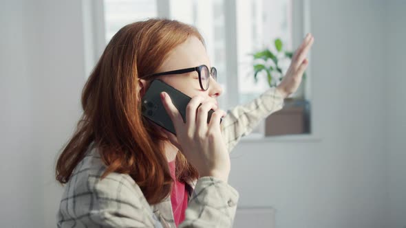 Woman Actively Talking on the Phone Turning to the Camera and Smiling