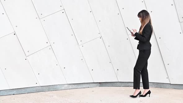 Business Woman in Corridor Using Tablet Computer Texting Walking in Corporate Office Building