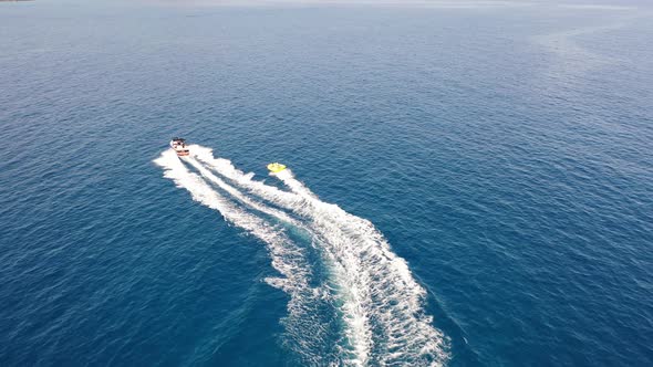 Aerial View of a Motor Boat Towing a Tube. Elounda, Crete, Greece