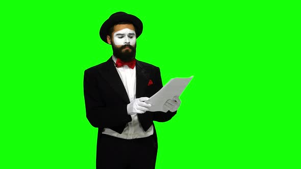 Unhappy Man Mime Reads About Something on Paper, Green Screen