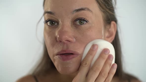 The Girl Removes the Mask From Her Face with a Sponge