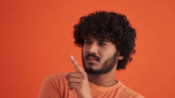 Cheerful curly-haired Indian man having an idea