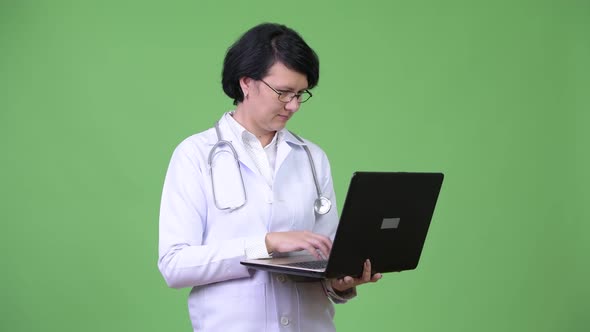 Beautiful Woman Doctor with Short Hair Using Laptop