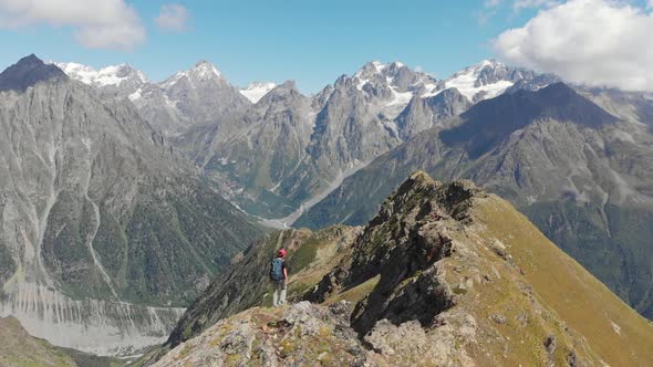 Woman with Backpack Hiking on Mountain Ridge in Caucasus Mountains Georgia