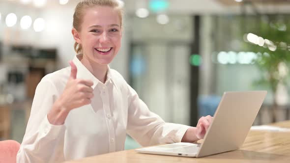 Positive Young Businessman with Laptop Doing Thumbs Up