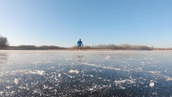 Man Skating on Ice on Lake in Winter Sunny Day.