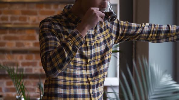 Mixed race man drinking coffee and looking over the window