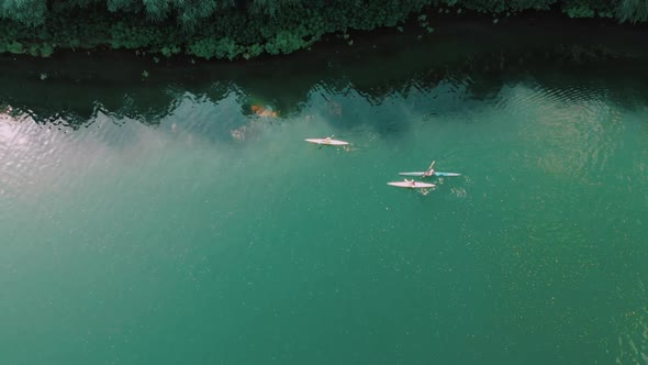 Wonderful Aerial Footage of Men Swimming in Kayak on Blue River Water. Drone View. Following High