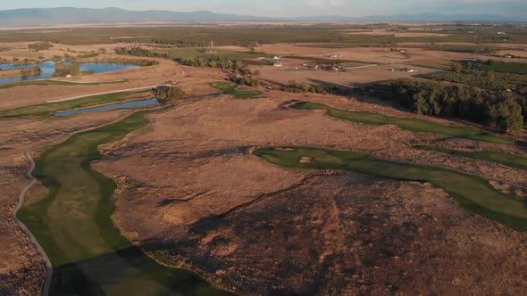Aerial view of California golf course, which is perfectly green, and the surrounding drought conditi