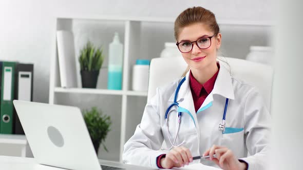 Professional Young Medical Worker Enjoying Break at Modern White Clinic Interior Looking at Camera