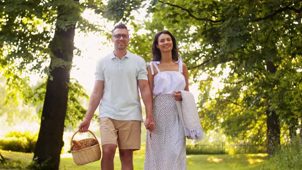 Happy Couple with Picnic Basket at Summer Park
