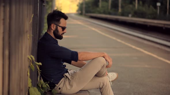 Businessman Hurries To Work And Sitting On Railway Train Station Platform. Μan Waiting Transport .