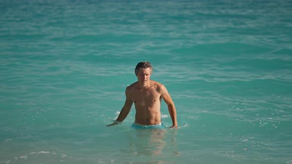 Slow Motion of Muscular Athletic Man on Beach in Turquoise Water of Mediterranean Sea in Oludeniz