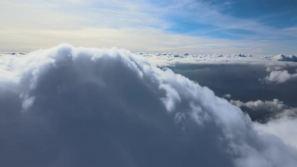 Aerial View From Airplane Window at High Altitude of Earth Covered with White Puffy Cumulus Clouds